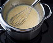Bowl of mixture of egg yolks and sugar in pan of hot water for preparing sorbet, step 1
