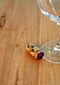 Close-up of wineglass with cork on wooden table