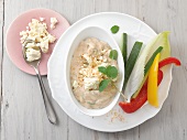 Bean hummus with sliced peppers and feta cheese on plate