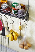 Groceries and utensils hanging from a wall shelf in a student kitchen