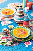 Carrot and grape soup on a colourfully decorated table