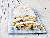 Cheese cake strudel with icing sugar on serving board