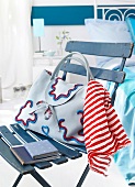 Cloth handbag with red and white striped scarf and diary on blue chair