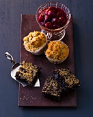 Banana and cherry muffins with cranberry brownies on wooden board