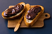 Baguette with chocolate nut cream on chopping board