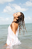 Woman with long brown hair wearing a white shirt in the sea