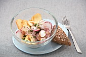 Marinated cheese with radishes in bowl