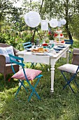 Gedeckter Tisch im sommerlichen Garten dekoriert mit Lampions