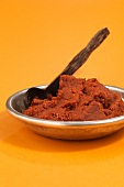 Curry paste in bowl on yellow background