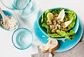Fresh salad with quinoa in bowl and slice of bread on plate