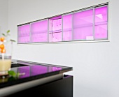 Kitchen cabinet in wall with pink LED lighting
