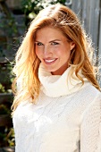 Portrait of attractive blonde woman wearing white turtleneck sweater, smiling