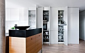 White kitchen cabinet with crockery in kitchen