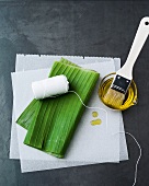 Banana leaves, thread, oil, brush and waxed paper