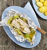 Foil fish with mustard butter on plate