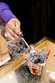 Person burning incense resin in bowl in Salalah, Dhofar, Oman