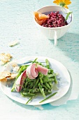 Green beans salad with herring and beetroot tartar with smoked salmon in serving dish