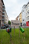 Watering cans hanged on sign board of Banane on Bonner Street, Southtown, Cologne, Germany