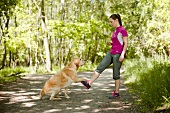 Side view of woman in sportswear performing fitness exercise with dog