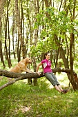 Woman in sportswear performing fitness exercise for triceps with dog, smiling