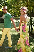 Couple wearing colourful summer outfit having fun in garden