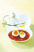 Fresh tomato sauce with hard boiled egg in serving dish