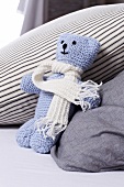 Blue knitted teddy with white scarf