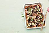 Vegetable pizza in baking dish on white background