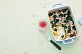 Polenta gratin in casserole on white background, copy space
