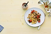 Grilled polenta with mushrooms and cherry tomatoes on plate