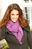 Portrait of attractive woman wearing green jacket and purple scarf, smiling