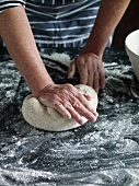 Close-up of hand kneading dough for preparing bread, step 4