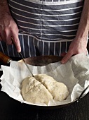 Close-up of hand cutting dough with knife