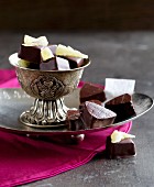Chilli-pineapple cubes and nougat pralines on a silver plate and in a bowl