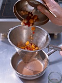 Straining juice from fruits through sieve