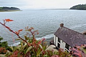 View of sea with boat house in Laugharne, Carmarthenshire, Wales, UK