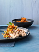 Grilled swordfish with mango salsa and sweet potato chips in serving dish
