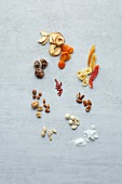 Different types of dried fruits, nuts and seeds on gray background
