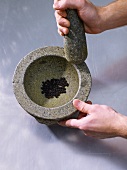 Pestle with pepper and mortar to crush it