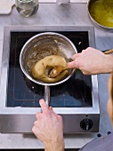 Adding flour and mixing in saucepan to prepare choux pastry