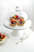 Chocolate mint tart on cake stand covered with glass lid