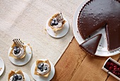 Small stracciatella cake with blueberries and chocolate tart, overhead view
