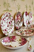 Plates and dishes with floral designs on table and against wall