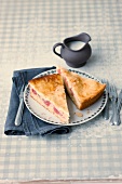 Two pieces of rhubarb cake on plate with milk jar