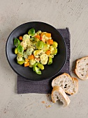 Bowl of brussels sprouts with pumpkin and slices of bread, overhead view