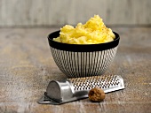 Mashed potatoes in bowl with grater at side