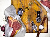 Watches on wooden chopping board with steaks