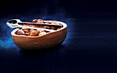 Nuts with nutshell and nutcracker in wooden bowl