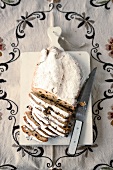 Pieces of Christmas stollen with knife on chopping board
