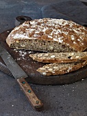 Sliced loaf of hazelnut bread on wooden board